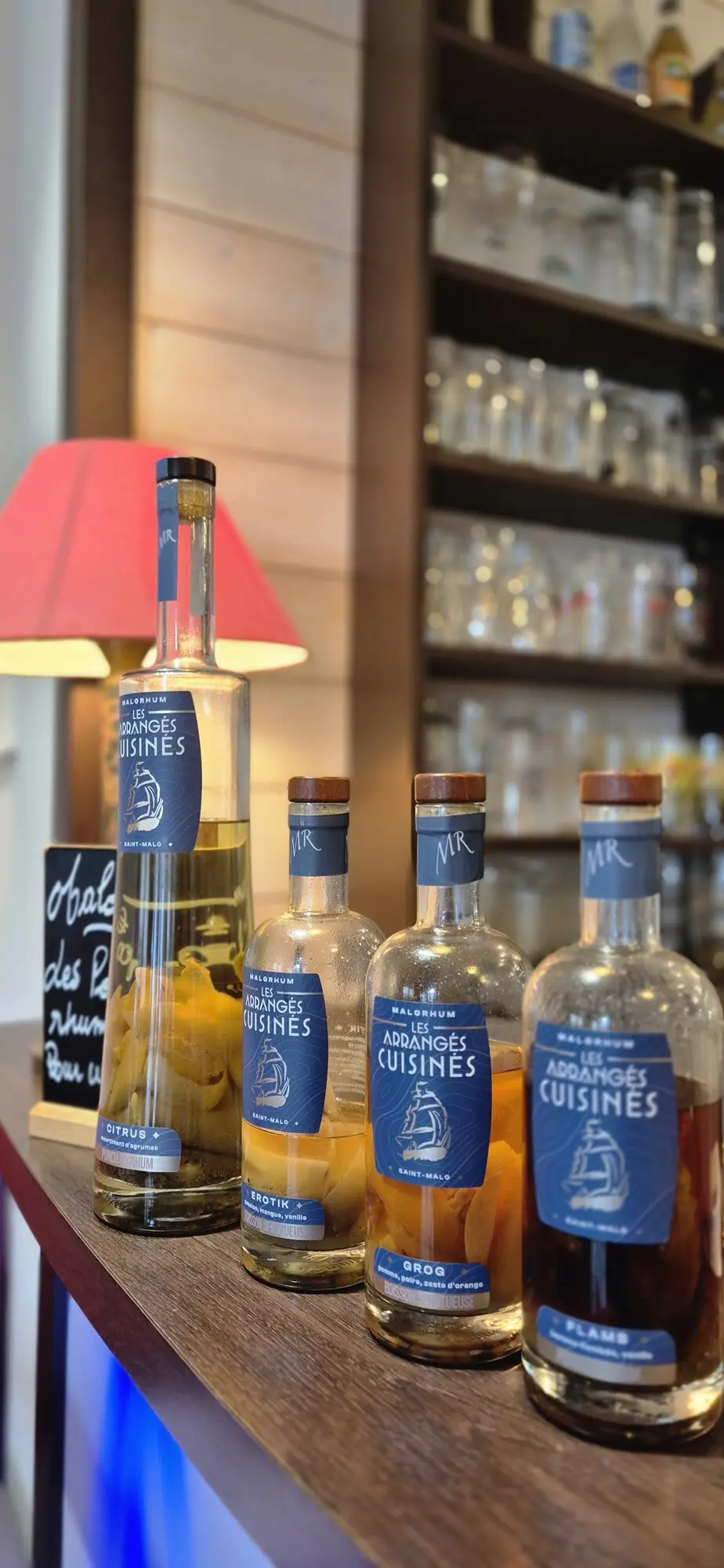 Étagère de rhums arrangés maison derrière le comptoir