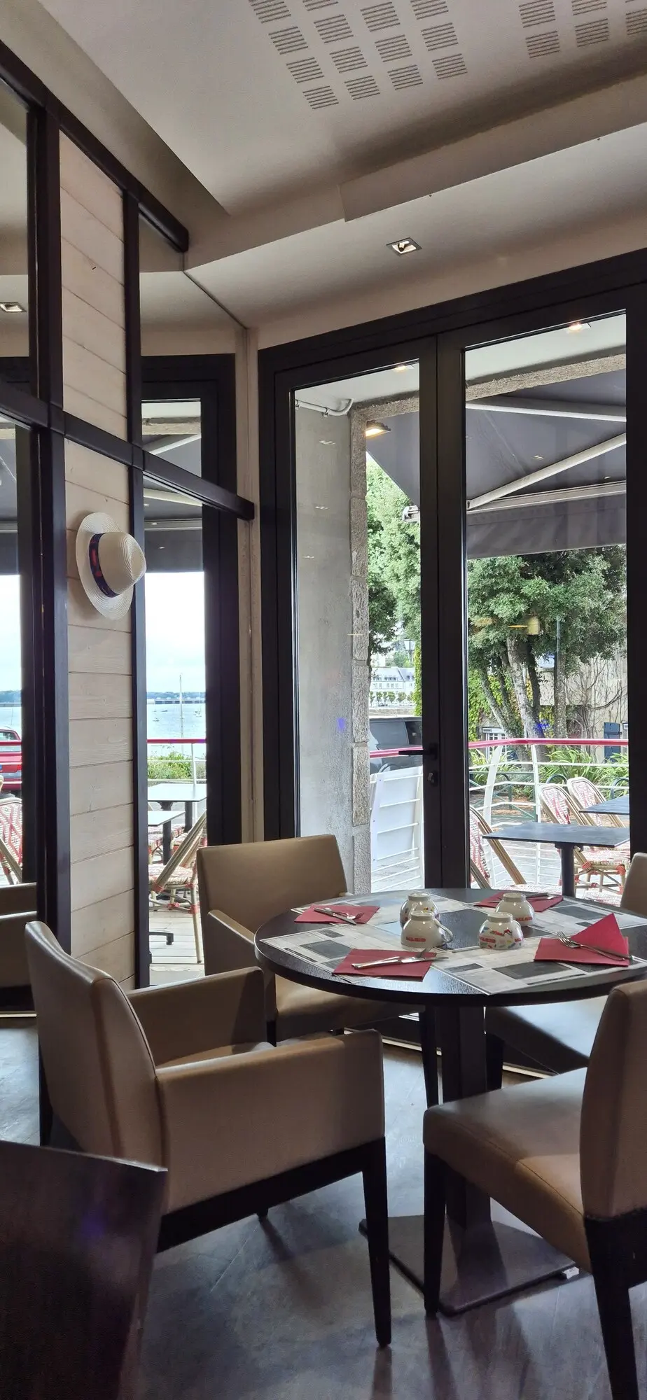 La salle de la crêperie, baies vitrées ouvertes sur la terrasse et le port